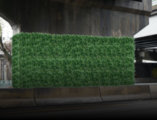 urban wall formerly tagged with graffiti now covered completely with lush synthetic ivy panels. Show before/after or just the “after” with ivy fully installed. Gritty city alley or street wall, contrast between clean ivy and urban backdrop, no people, visual focus on transformation